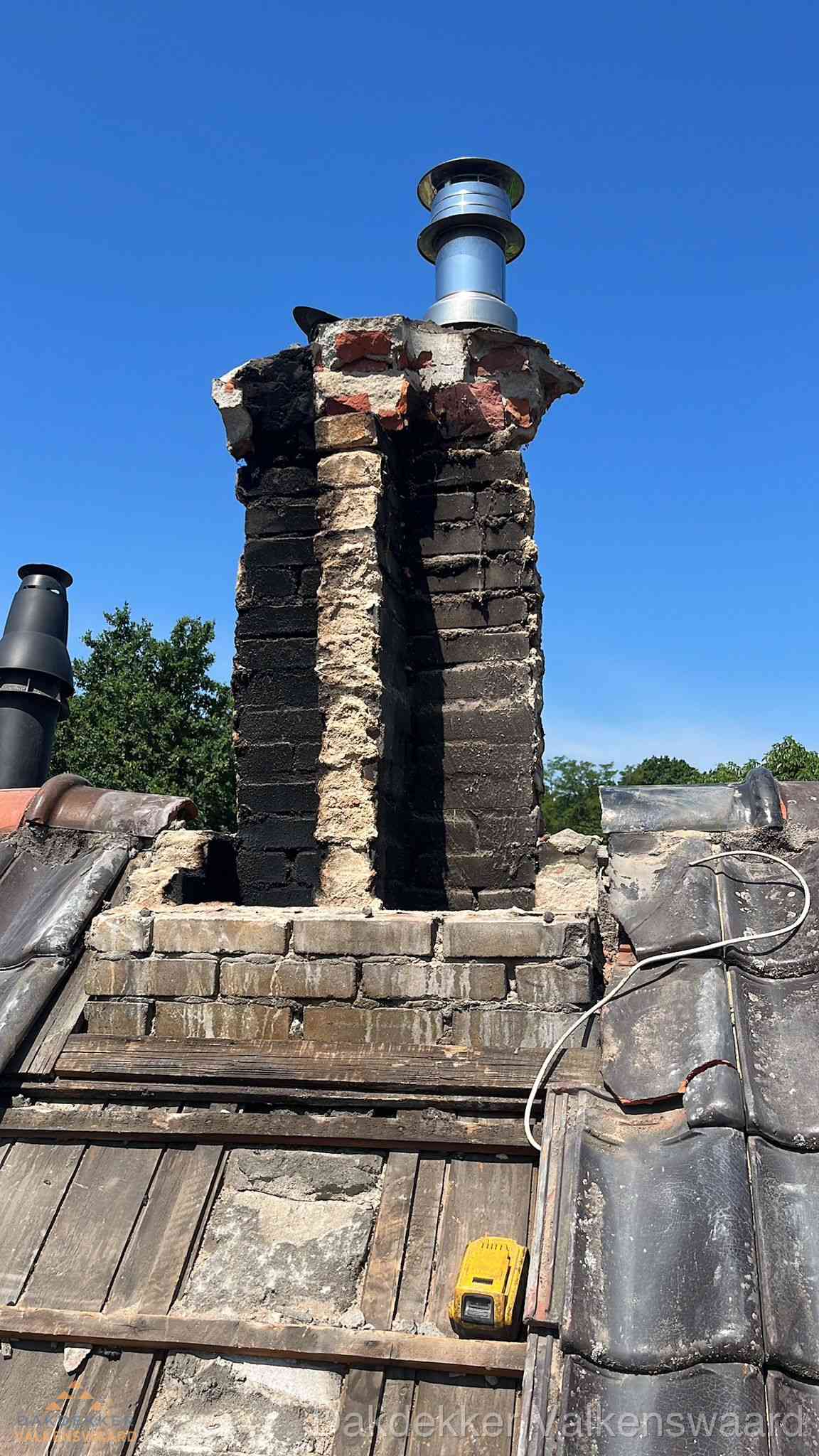 Beschadigde schoorsteen met nieuwe rookgasafvoer op oud dak in Valkenswaard
