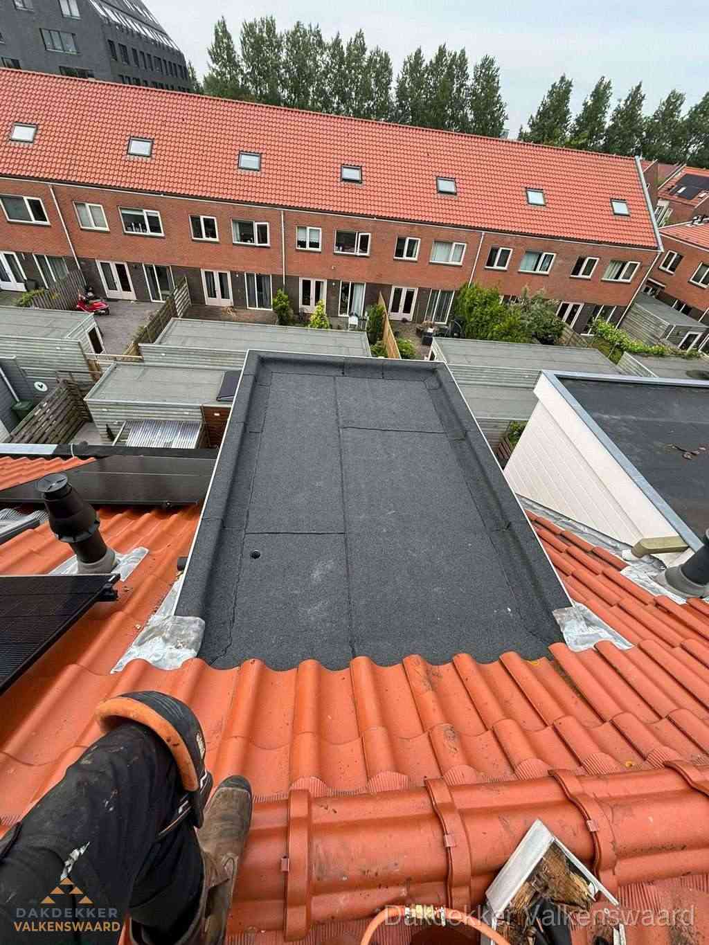 Bitumen dak reparatie op plat dak tussen dakpannen in Valkenswaard
