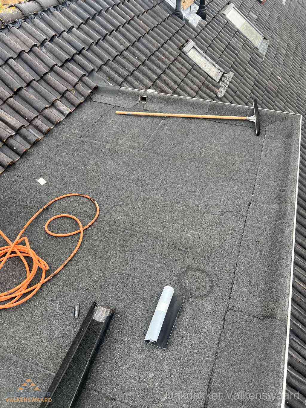 Plat dak reparatie met gereedschap en loodstroken in Valkenswaard