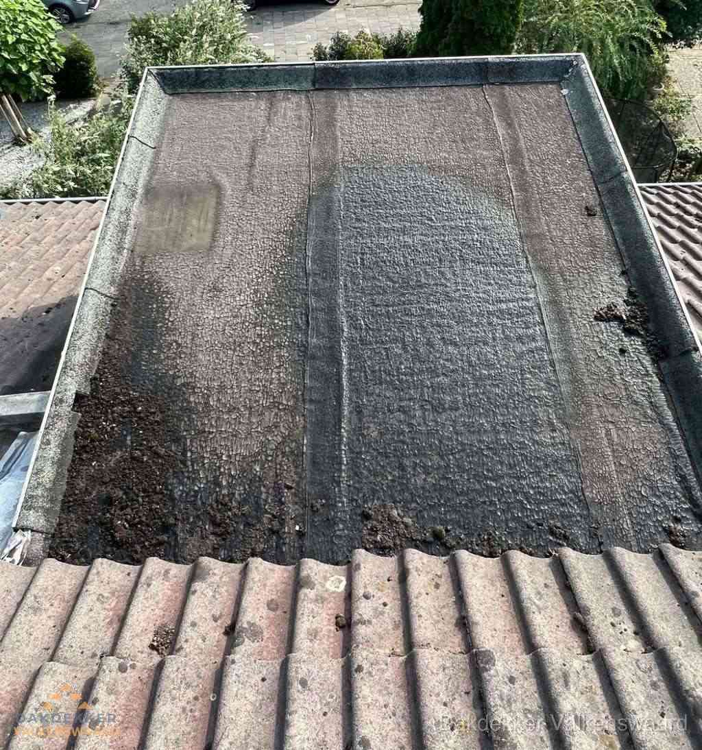 Verouderd plat dak met bitumen en slijtage voor lekkage inspectie in Valkenswaard